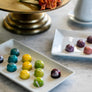 Colorful, shiny chocolate bonbons on various platters