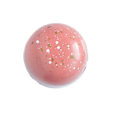 Passion Fruit chocolate bonbon.  Peach colored bonbon with white and gold specks.  The Chocolate Palette Utah
