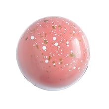 Passion Fruit chocolate bonbon.  Peach colored bonbon with white and gold specks.  The Chocolate Palette Utah