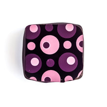 A peanut butter and jelly chocolate bonbon featuring a pattern of pink and purple concentric circles.  The Chocolate Palette Salt Lake City Utah.  Best chocolates in utah