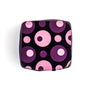 A peanut butter and jelly chocolate bonbon featuring a pattern of pink and purple concentric circles.  The Chocolate Palette Salt Lake City Utah.  Best chocolates in utah