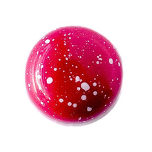 Red chocolate bonbon with white specks Fleur de Sel caramelzed milk chocolate ganache with french sea salt.  The Chocolate Palette Salt Lake City Utah