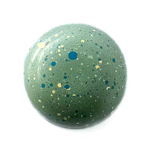 Lemon Thyme caramel a green chocolate bonbon with blue and yellow specks.  The Chocolate Palette Salt Lake City, Utah